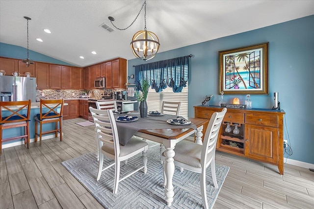 dining room featuring a chandelier and vaulted ceiling