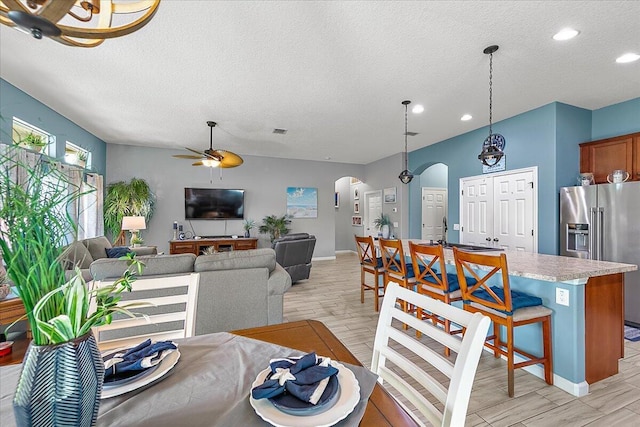 living room with ceiling fan and a textured ceiling