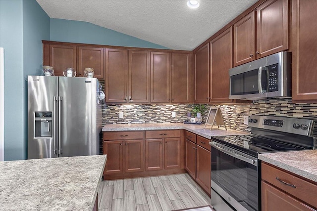 kitchen featuring appliances with stainless steel finishes, lofted ceiling, decorative backsplash, light hardwood / wood-style floors, and a textured ceiling