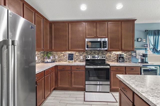 kitchen featuring wine cooler, tasteful backsplash, a textured ceiling, and appliances with stainless steel finishes