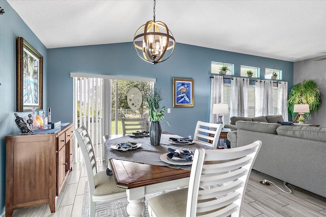 dining area featuring lofted ceiling, an inviting chandelier, and a textured ceiling