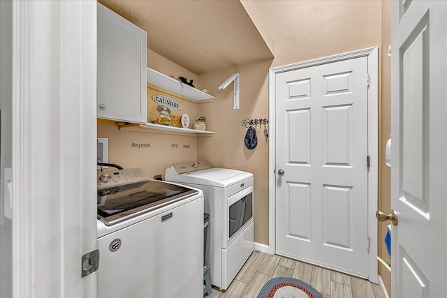 laundry area with separate washer and dryer, cabinets, and a textured ceiling