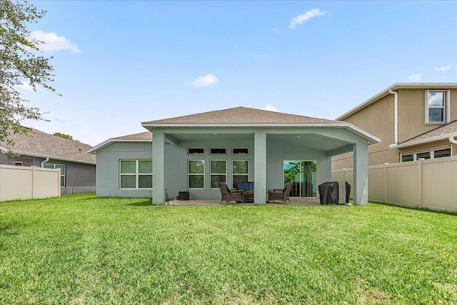 rear view of house featuring a yard and a patio area