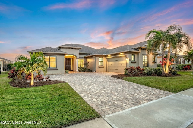 view of front of home with a garage and a lawn