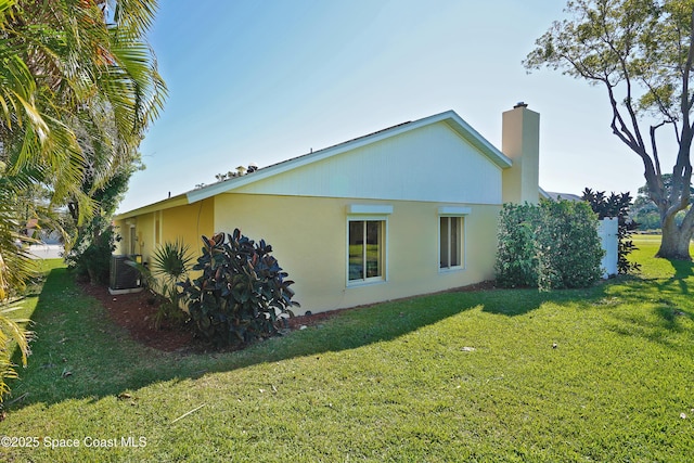 view of property exterior with central AC, a lawn, a chimney, and stucco siding