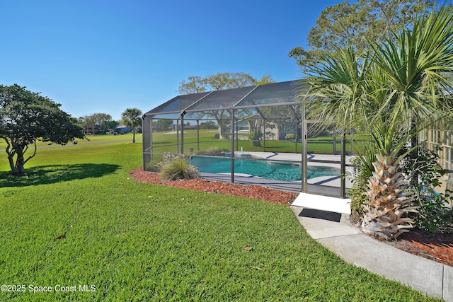 pool featuring glass enclosure and a lawn