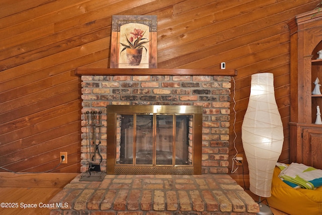 room details featuring a brick fireplace and wooden walls