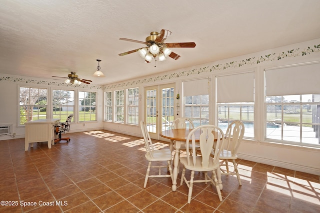 unfurnished sunroom with a ceiling fan