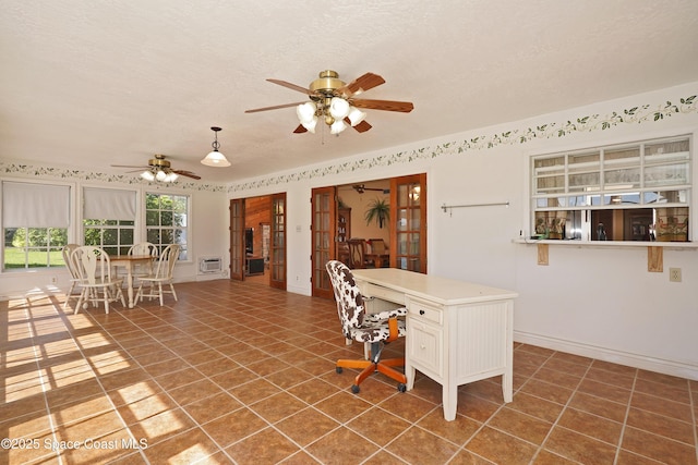 tiled dining area featuring ceiling fan, baseboards, and a textured ceiling