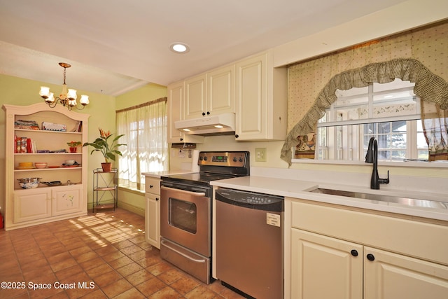 kitchen with stainless steel appliances, light countertops, a sink, a chandelier, and under cabinet range hood