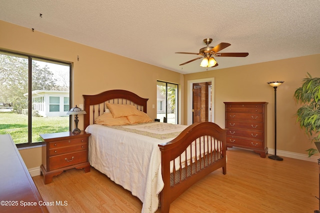 bedroom with a textured ceiling, ceiling fan, light wood finished floors, and baseboards