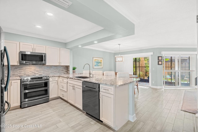 kitchen featuring appliances with stainless steel finishes, sink, backsplash, light stone counters, and kitchen peninsula