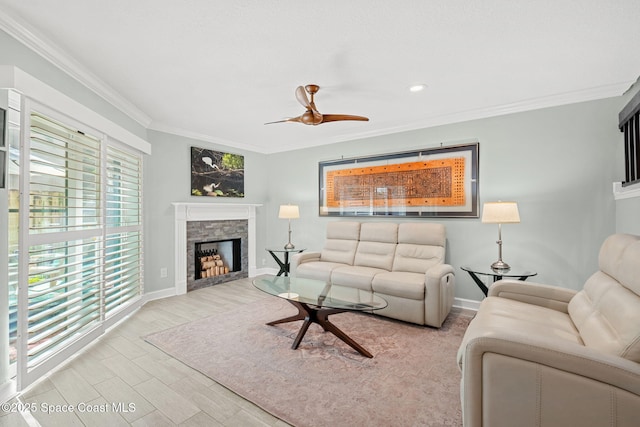 living room featuring crown molding, ceiling fan, and a fireplace