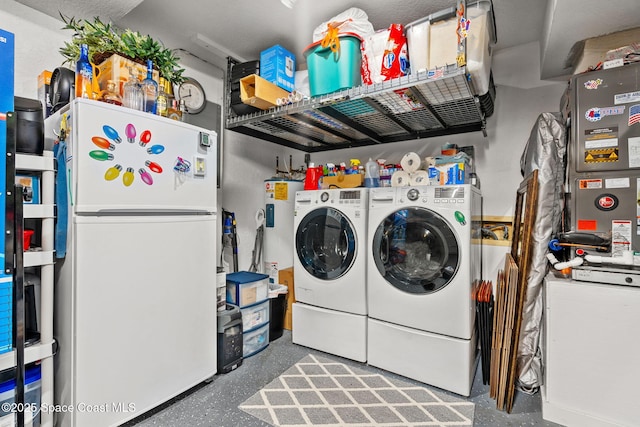 clothes washing area featuring water heater and independent washer and dryer