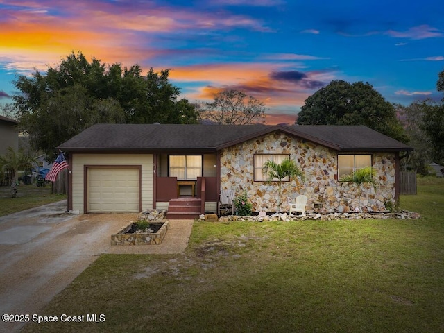 single story home featuring a garage and a lawn