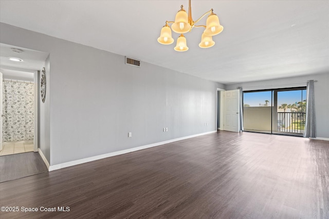 empty room with visible vents, baseboards, and wood finished floors