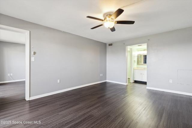 unfurnished room with ceiling fan, dark wood-style floors, visible vents, and baseboards