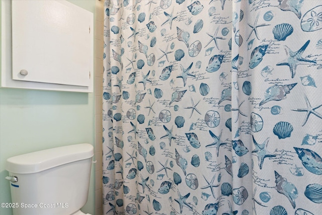 bathroom featuring curtained shower and toilet