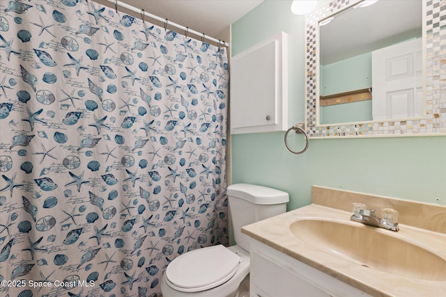 bathroom featuring toilet, vanity, and a shower with curtain