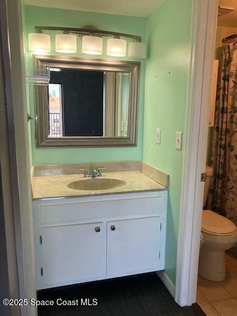 full bathroom featuring vanity, tile patterned flooring, and toilet