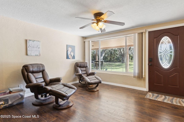 foyer featuring ceiling fan, baseboards, dark wood finished floors, and a textured ceiling