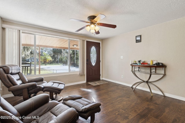 interior space featuring a ceiling fan, a textured ceiling, baseboards, and dark wood-type flooring