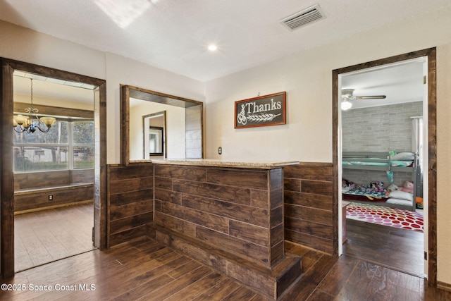 bathroom featuring ceiling fan with notable chandelier, wainscoting, wood finished floors, and visible vents