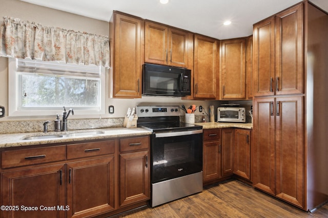 kitchen with dark wood-style floors, electric stove, brown cabinets, a sink, and black microwave