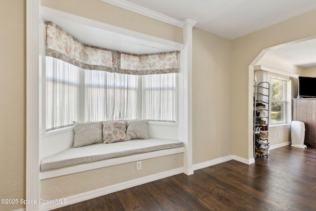 unfurnished room with baseboards, arched walkways, and dark wood-type flooring