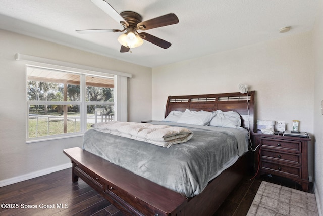 bedroom with a ceiling fan, dark wood finished floors, and baseboards