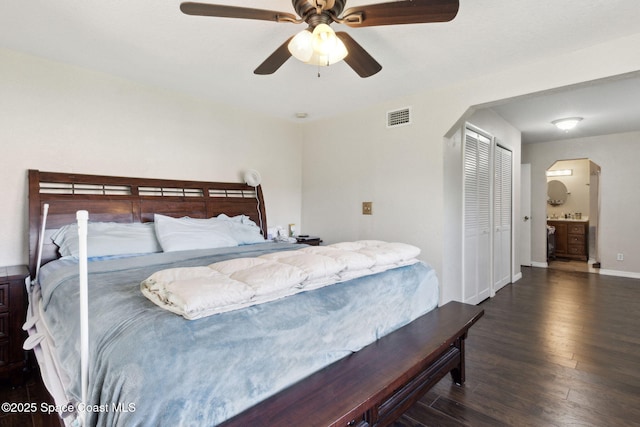 bedroom featuring baseboards, visible vents, arched walkways, ceiling fan, and dark wood-type flooring