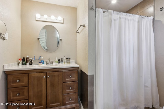 bathroom with curtained shower and vanity