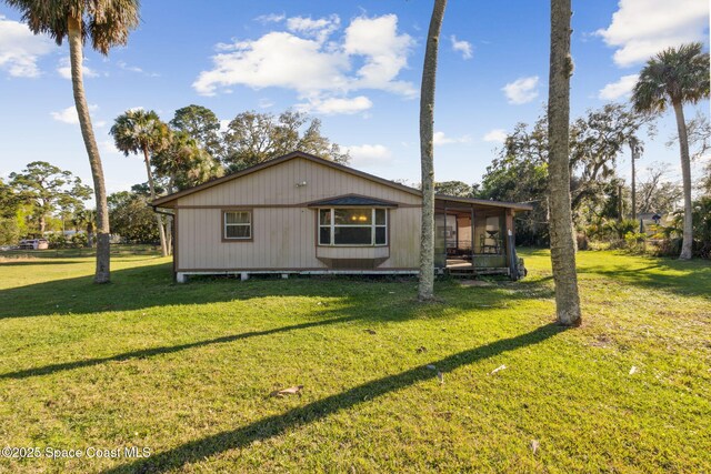 view of side of home featuring a yard and a sunroom