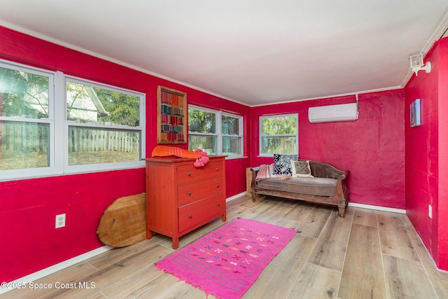 sitting room featuring an AC wall unit and light hardwood / wood-style floors