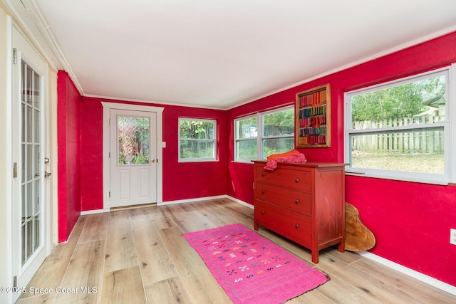 foyer with crown molding and light hardwood / wood-style flooring