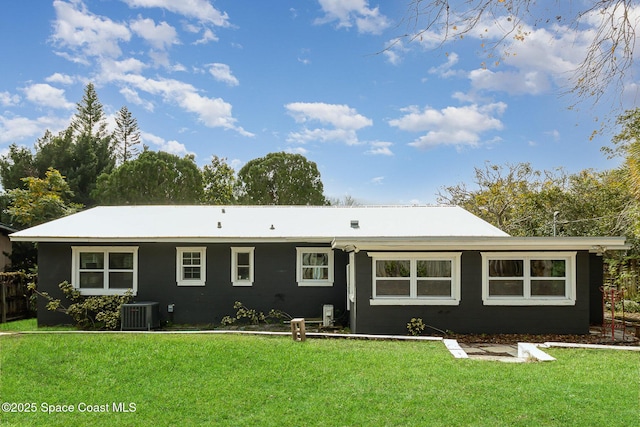 back of property featuring central AC unit and a yard