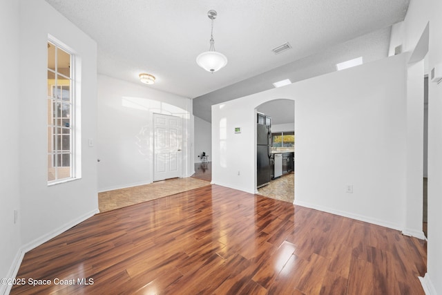 empty room featuring wood-type flooring and a textured ceiling