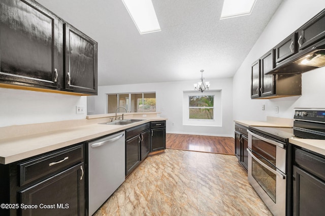 kitchen with sink, an inviting chandelier, a textured ceiling, appliances with stainless steel finishes, and pendant lighting