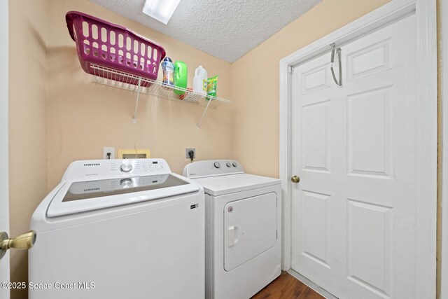 washroom with dark wood-type flooring, separate washer and dryer, and a textured ceiling