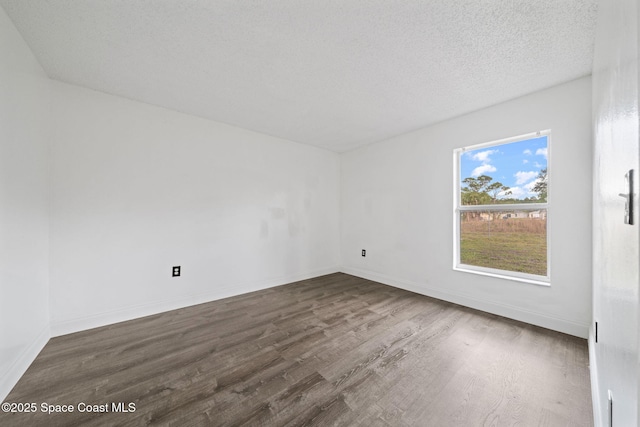 spare room with plenty of natural light, dark hardwood / wood-style floors, and a textured ceiling