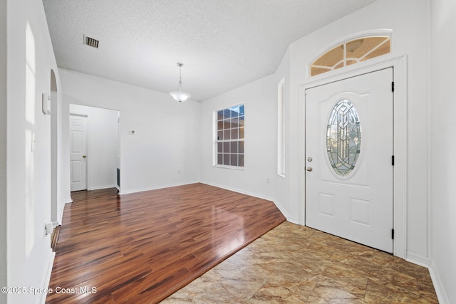 foyer entrance featuring wood-type flooring and a textured ceiling