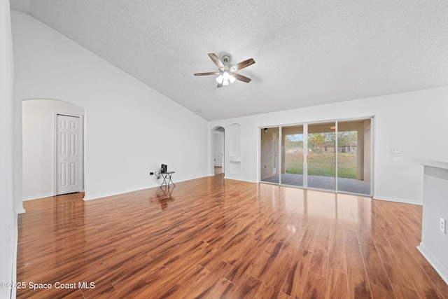 unfurnished living room featuring lofted ceiling, hardwood / wood-style floors, a textured ceiling, and ceiling fan