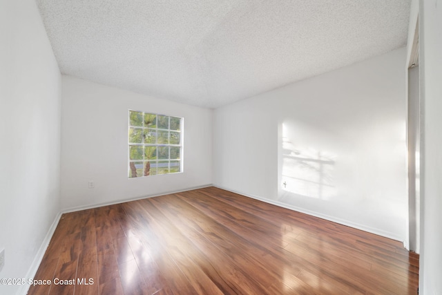 spare room with dark hardwood / wood-style flooring and a textured ceiling