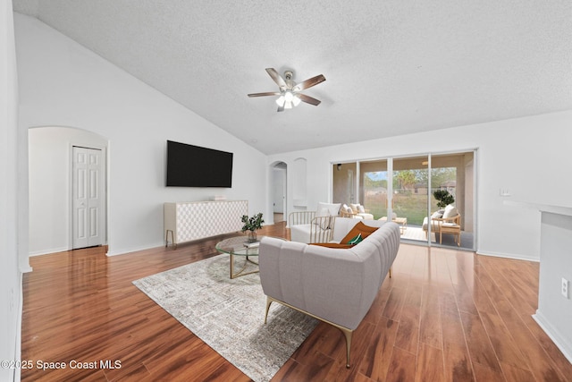 living room with wood-type flooring, high vaulted ceiling, a textured ceiling, and ceiling fan