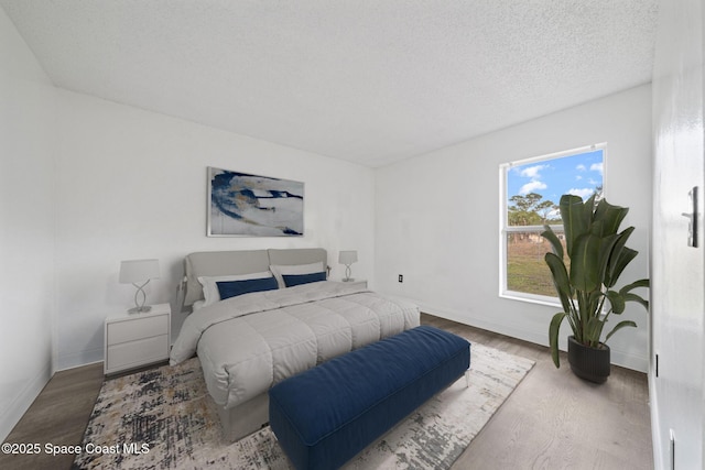 bedroom featuring hardwood / wood-style flooring and a textured ceiling