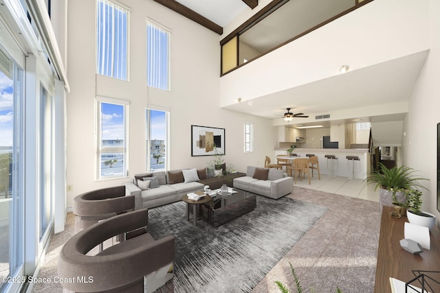 carpeted living room featuring a high ceiling, a wealth of natural light, and beam ceiling