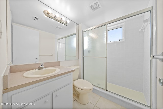 bathroom featuring tile patterned flooring, vanity, a shower with shower door, and toilet