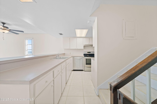 kitchen with light tile patterned flooring, sink, electric panel, stainless steel appliances, and white cabinets