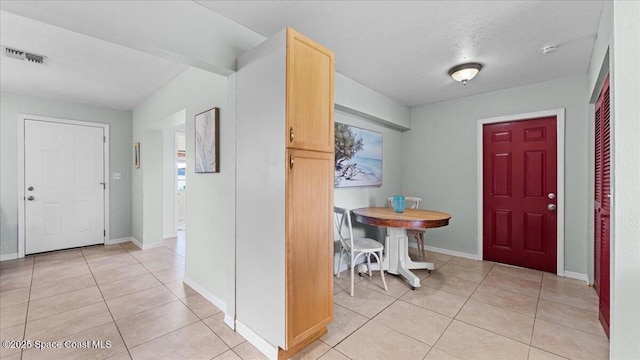 entrance foyer featuring light tile patterned flooring and a textured ceiling