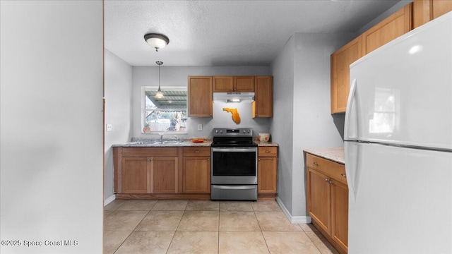 kitchen featuring sink, stainless steel electric range, light tile patterned floors, white fridge, and pendant lighting